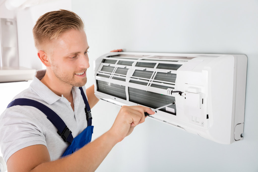 HVAC technician cleaning and repairing a ductless mini split AC in Farmington, UT