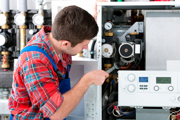 HVAC technician inspecting an indoor heating system in Farmington, UT