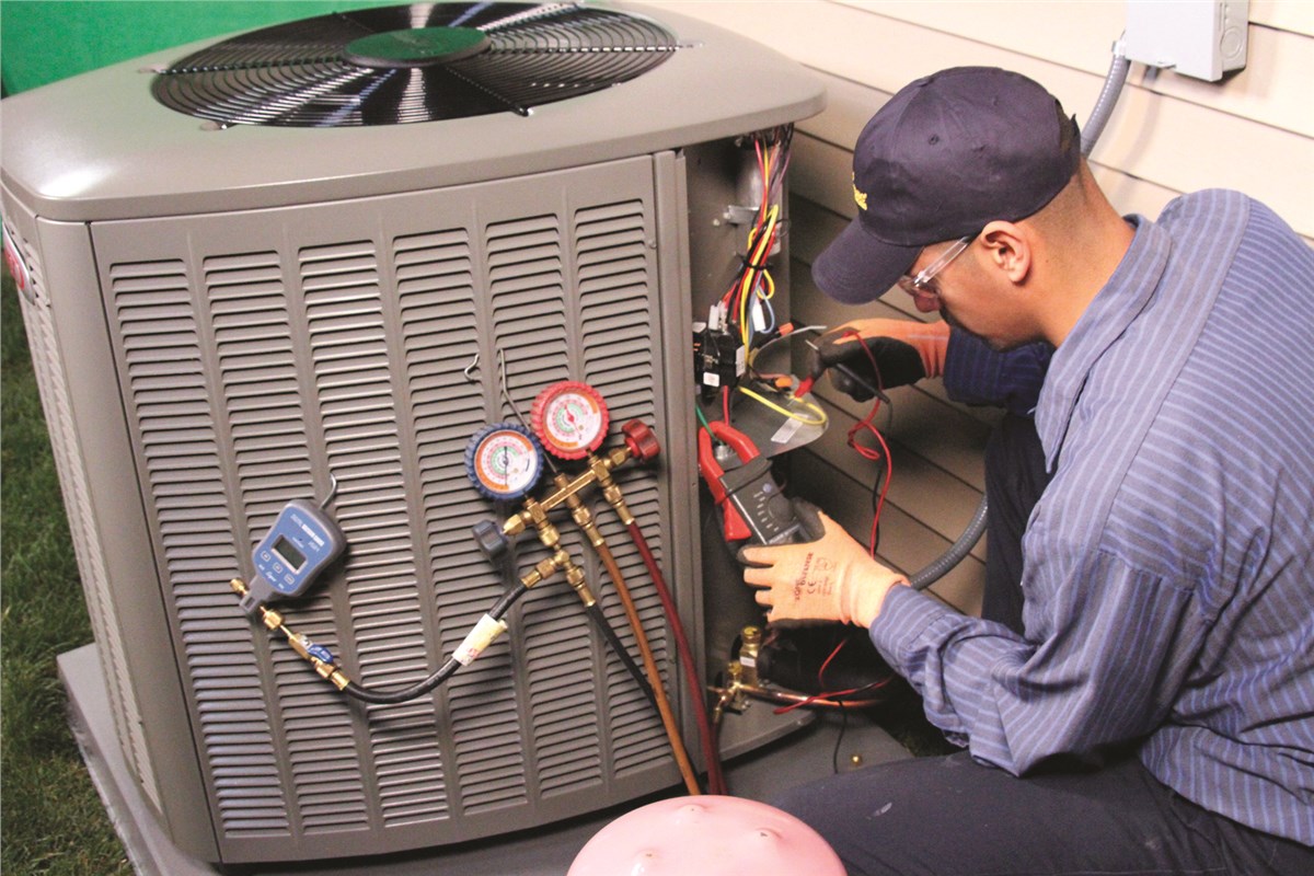 HVAC technician testing an outdoor air conditioning unit in Farmington