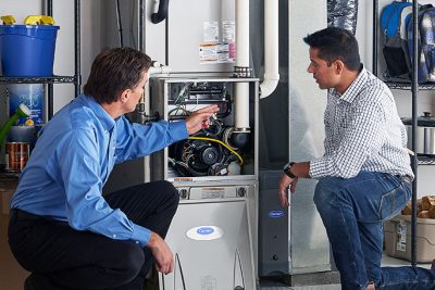 HVAC technician explaining furnace repair and maintenance to a homeowner in Farmington, UT