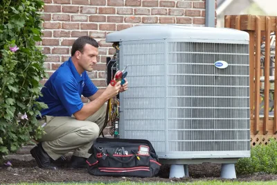 HVAC technician inspecting an outdoor air conditioning unit in Farmington, UT